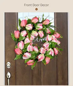 Close-up of pink and white tulip wreath with green leaves on dark wooden door