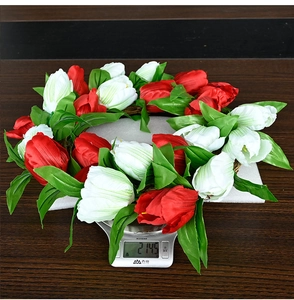 Detailed top view of a colorful tulip wreath being weighed on a scale showing 214.5g