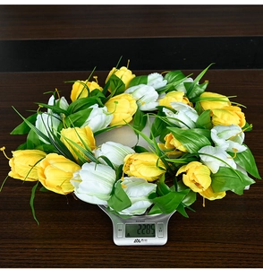 Detail view of artificial tulip wreath on a digital scale showing 228.5g weight