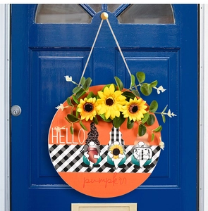 Détail d'une plaque de porte en bois avec gnomes d'automne et ruban à carreaux sur porte bleue