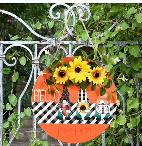 Gros plan d'une plaque Hello Pumpkin en bois avec des tournesols et des nains d'automne