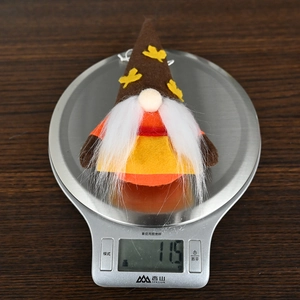 Macro view of a fall gnome plush ornament weighing 11.5g with maple leaf decoration