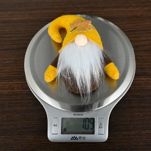 Detail shot of fall gnome ornament weighing 10.9g on a scale for autumn decor