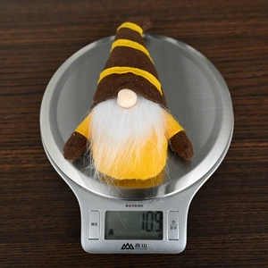 Detail shot showing a 10.9g autumn harvest gnome plush being weighed on a digital scale