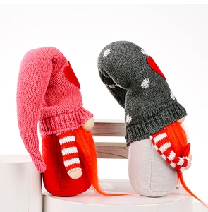 Detail of two knitted Valentine gnomes with pink and grey hats on white stands