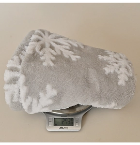 Detail showing grey plush Christmas tree skirt with white snowflake weighing 273.0g
