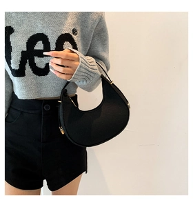 Detail of black felt crescent shoulder bag featuring adjustable metal buckle and textured fabric