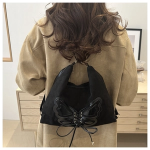 Détail du sac cabas noir à nœud papillon avec texture brossée et fermeture éclair métal