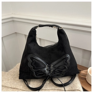 Détail du sac à main noir en daim avec design papillon à lacets et finitions dorées chic