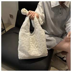 Close-up of white floral lace tote bag with detailed 3D daisy embroidery for summer