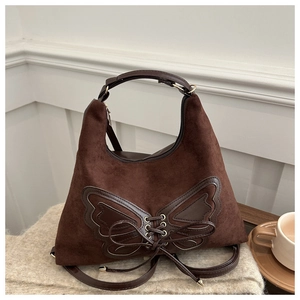 Détail du sac en daim marron foncé avec nœud décoratif en cuir et bandoulière