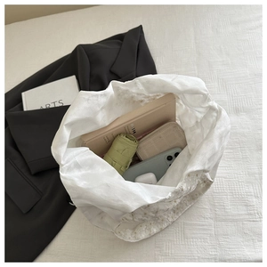 Spacious white lace tote bag interior showing daily items like a book and umbrella