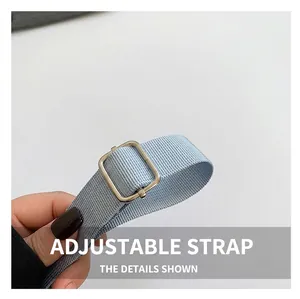 Détail de la bandoulière réglable en nylon bleu clair avec boucle en métal argenté poli