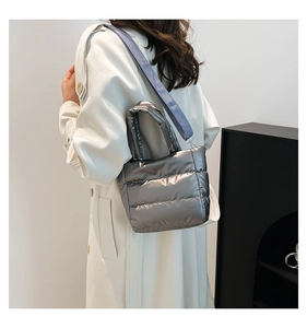 Détail du sac seau matelassé argenté métallisé avec bandoulière tissée bleu clair