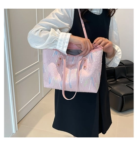 Detail of pink tote bag showing textured fabric and colorful wavy embroidery pattern