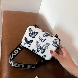 White butterfly print hard shell suitcase crossbody bag with a wide LOVE logo strap