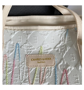 Macro shot of striped embroidery and embossed texture on the beige tote bag surface