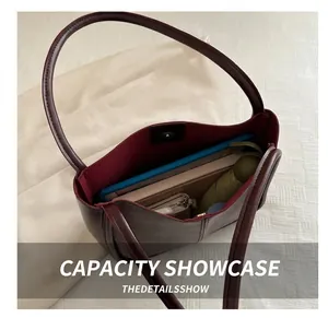 Interior capacity of the deep red leather tote bag showing space for tablet and umbrella