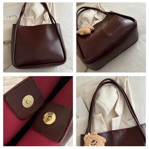 Detail view of large brown tote bag showing gold magnetic closure and plush bear charm
