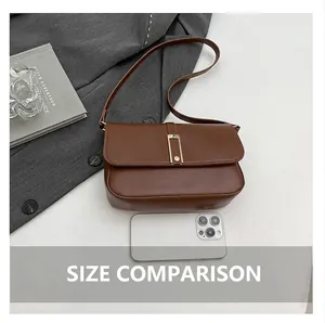 Detailansicht der braunen Leder-Schultertasche mit goldener Schnalle neben Smartphone