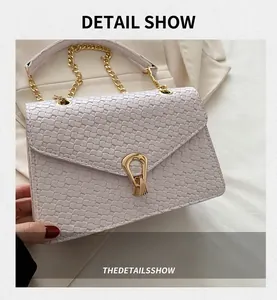 Détail macro de la texture tissée et boucle en fer à cheval dorée sur sac en cuir PU blanc