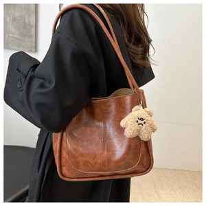 Detail view of vintage brown tote bag with textured leather and plush star charm