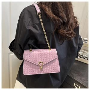 Detail of purple woven textured crossbody bag with gold horseshoe clasp and chain