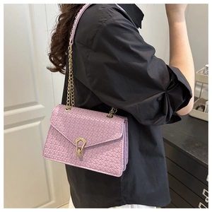 Close-up of lavender woven pattern shoulder bag with distinctive golden U-shaped clasp