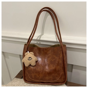 Retro brown tote bag featuring textured leather and a cute plush bear star charm detail