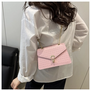 Pink woven crossbody bag with gold chain strap shown on model's shoulder from behind