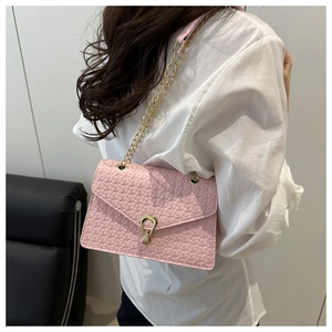 Détail du sac bandoulière tressé rose avec fermoir goutte doré et bandoulière chaîne