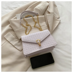 Detail of woven texture flap bag in light purple with gold chain strap and stylish buckle