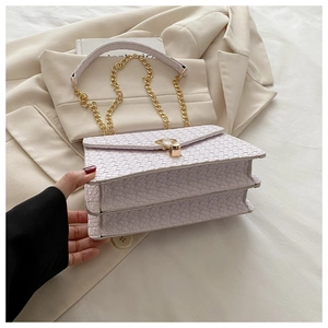 Close-up of woven texture and gold metal buckle on light purple flap shoulder bag