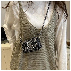 Détail du mini sac bandoulière en cuir avec motif python serpent noir et blanc élégant