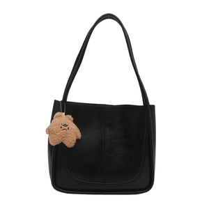 Large black matte leather tote bag with long straps and brown plush bear charm