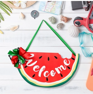Close-up of watermelon wooden welcome sign with bow detail and summer travel props