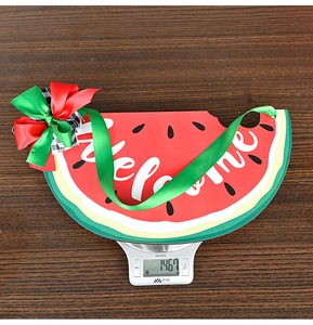 Detail shot of a wooden watermelon door sign with a welcome text and decorative bow