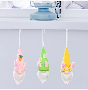 Close-up of Easter faceless gnome plush ornaments with rabbit ears and carrots in pastel tones