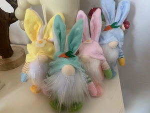 Set of four pastel Easter bunny gnomes with long ears and floral details on white surface