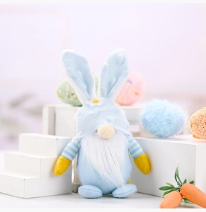 Close-up of Easter rabbit gnome plush with blue ears and white flower on decorative display