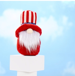 Gnome patriotique en peluche avec chapeau rayé sur socle blanc devant ciel bleu