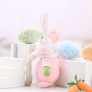 Pink Easter bunny gnome plush with white ears and green bows on a decorative display