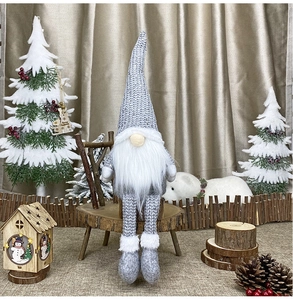 Close-up of Nordic Christmas gnome plush doll in a snowy pine forest decorative scene