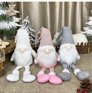 Close-up of three knitted Christmas gnomes with sequins and long legs for festive decor