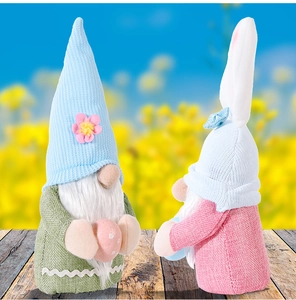 Detail of plush Easter gnomes with bunny ears and polka dot eggs on wooden surface