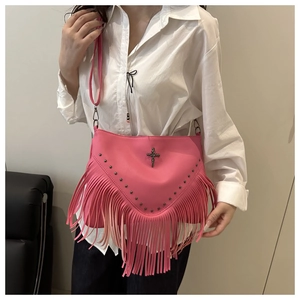 Détail macro du sac punk rose avec franges en cuir et clous métalliques vintage