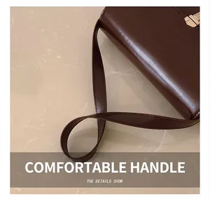 Close-up of dark brown leather handle and fine stitching on a square crossbody bag