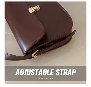 Detail of adjustable shoulder strap and gold buckle on vintage brown leather bag