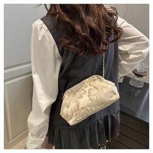 Détail du sac jacquard floral crème avec texture gaufrée et bandoulière chaîne dorée