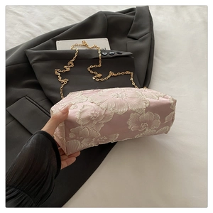 Détail du sac à chaîne rose avec broderie florale 3D et élégante bandoulière en chaîne dorée